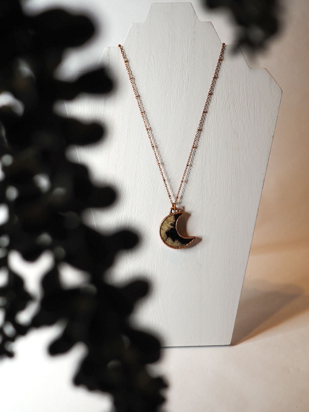 Noon-shaped copper electroformed pendant featuring petrified palm wood on copper chains