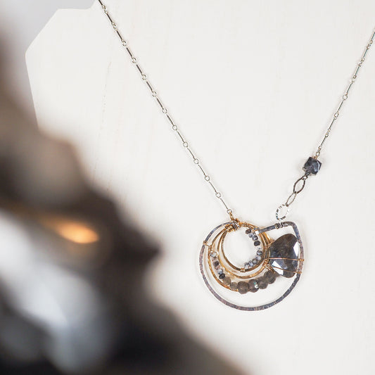 Dendritic opal and faceted labradorite beads swirl into a labradorite luster drop in a nod to the the ancient ammonite in this hand-formed sterling silver statement necklace!