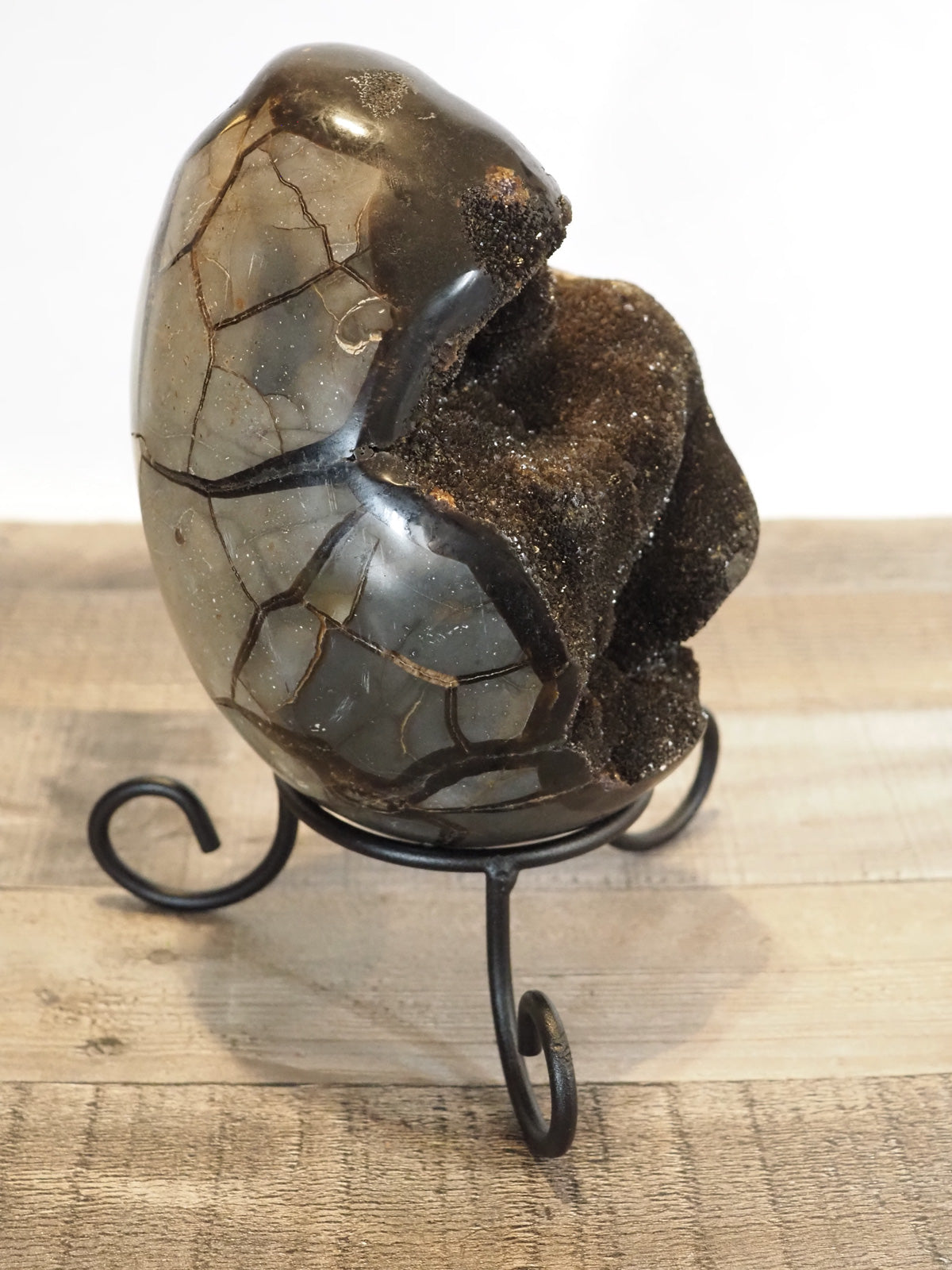 XL 7.25" tall Septarian Dragon Egg with Black Druzy, shown on its included wrought iron stand