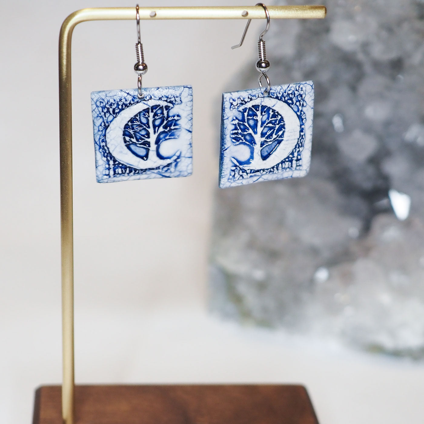 Hand-made, blue and white, square dangle earrings with a large crescent moon and forest scene
