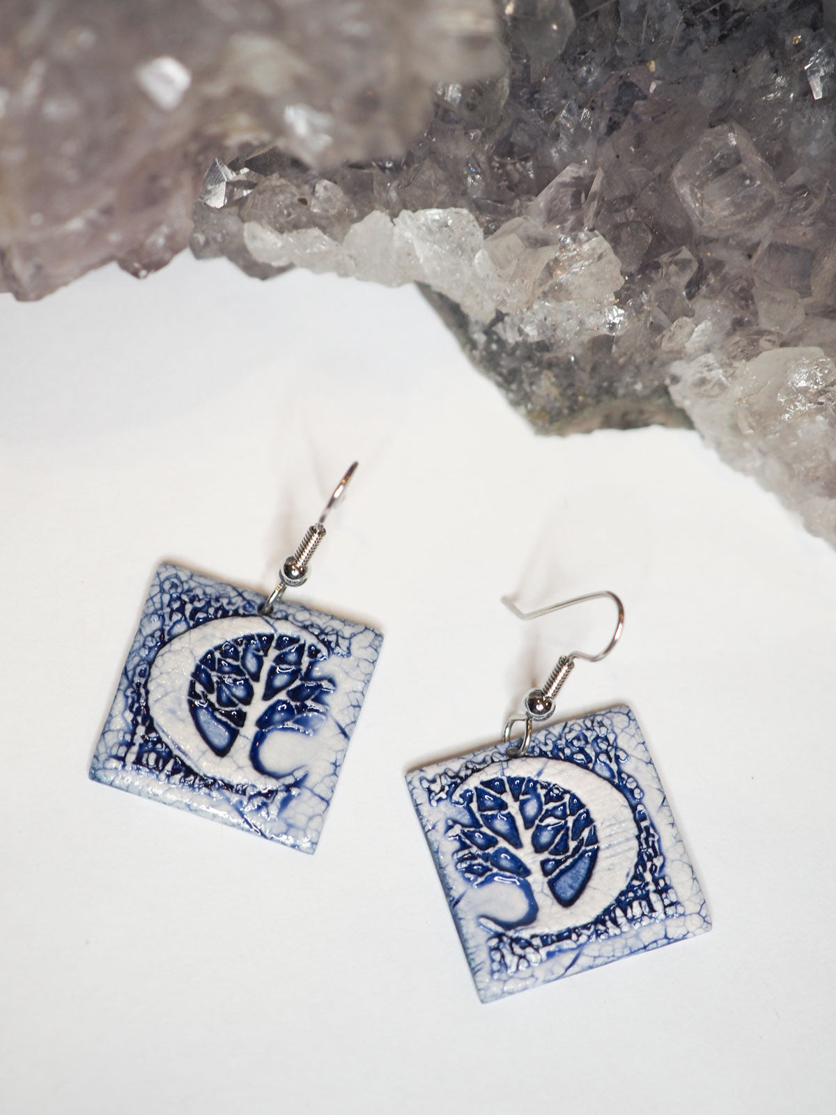 Hand-made, blue and white, square dangle earrings with a large crescent moon and forest scene