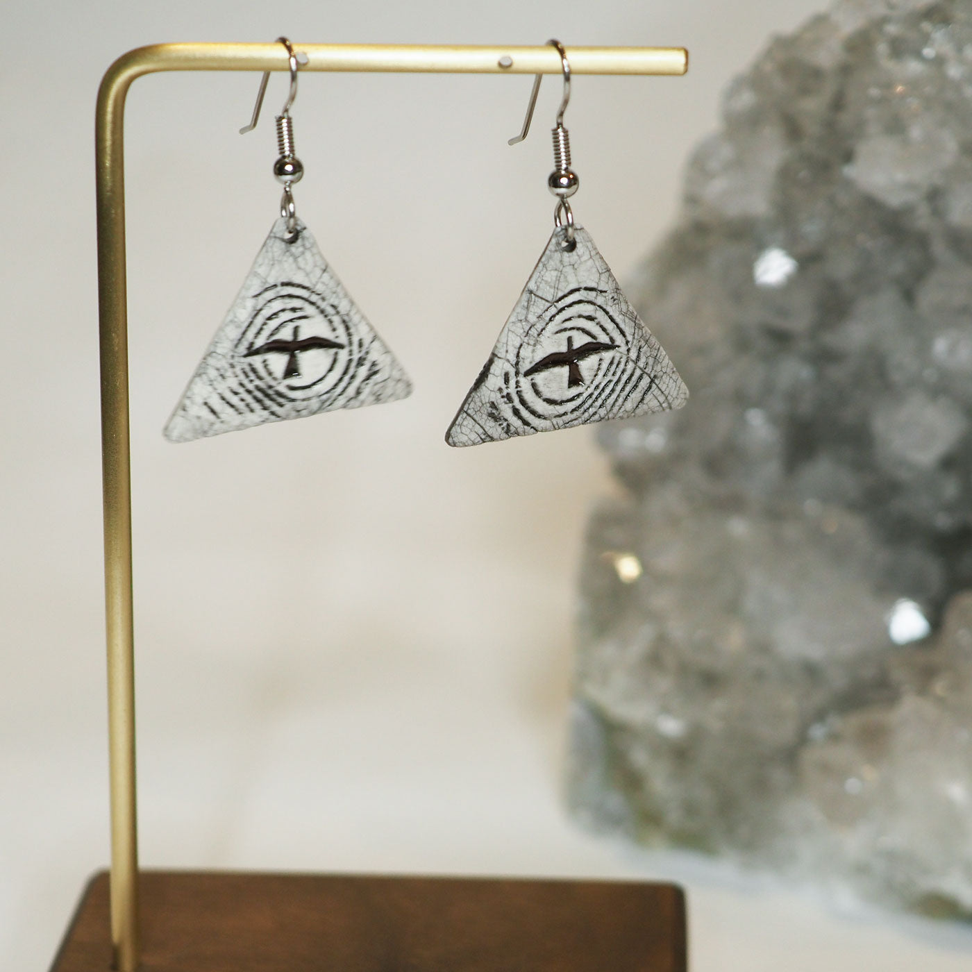 Hand-made triangular ceramic dangle earrings featuring a flying bird silhouetted against a stylized moon 