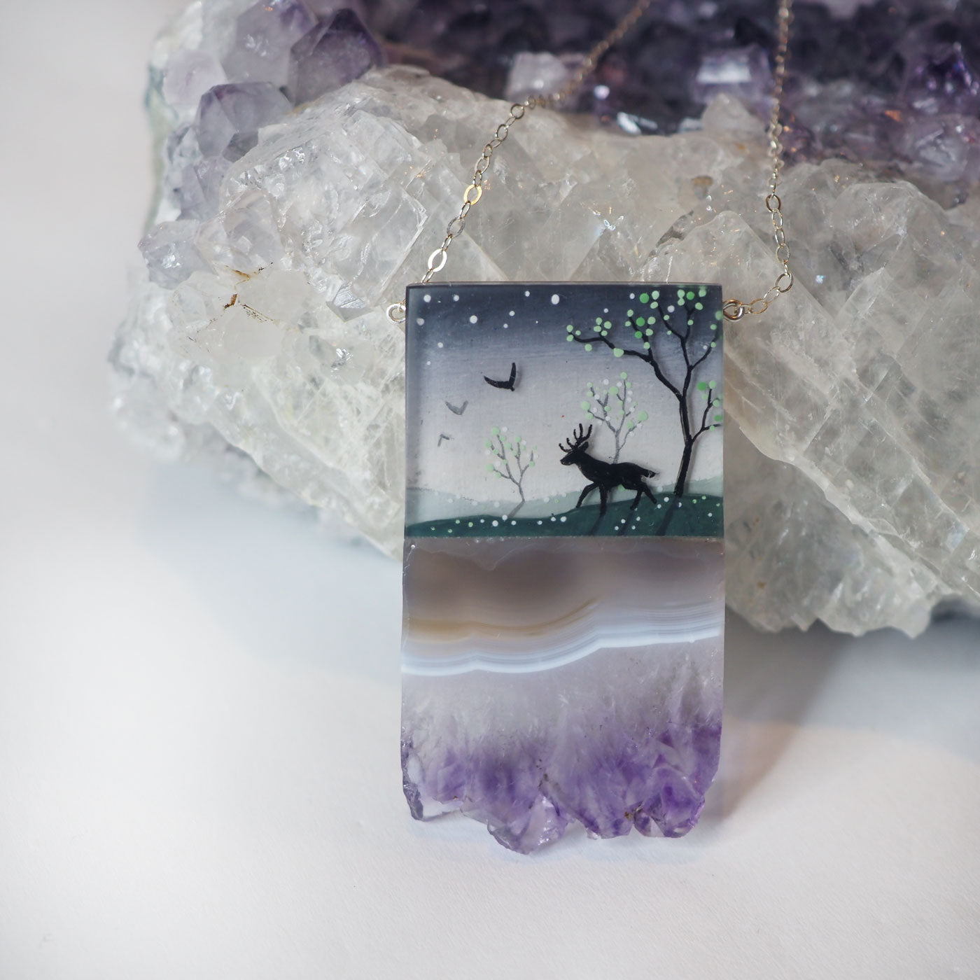 Hand-painted resin and amethyst slice necklace with a bird and deer in a forest scene