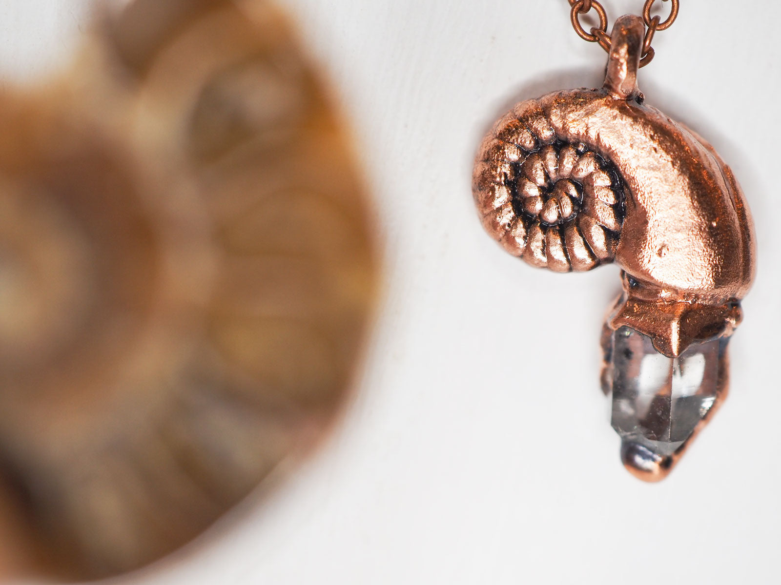 Copper nautilus-shaped pendant with a herkimer diamond, on a copper chain
