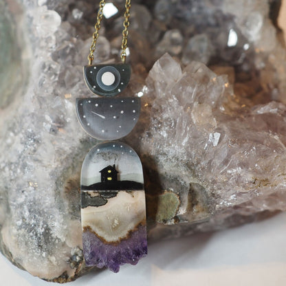 Hand-painted resin and amethyst slice necklace featuring 2 half circles on top of a silhouette of a house at night under a full moon and shooting stars