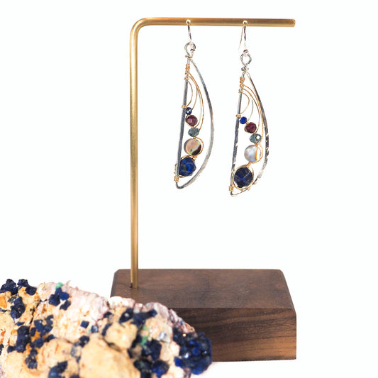 Lapis gemstone, abalone, faceted garnet, and sparkling crystals hang like a solar system of suspended planets, bejeweling these hand-formed sterling silver and 14k gold filled dragonfly wing earrings