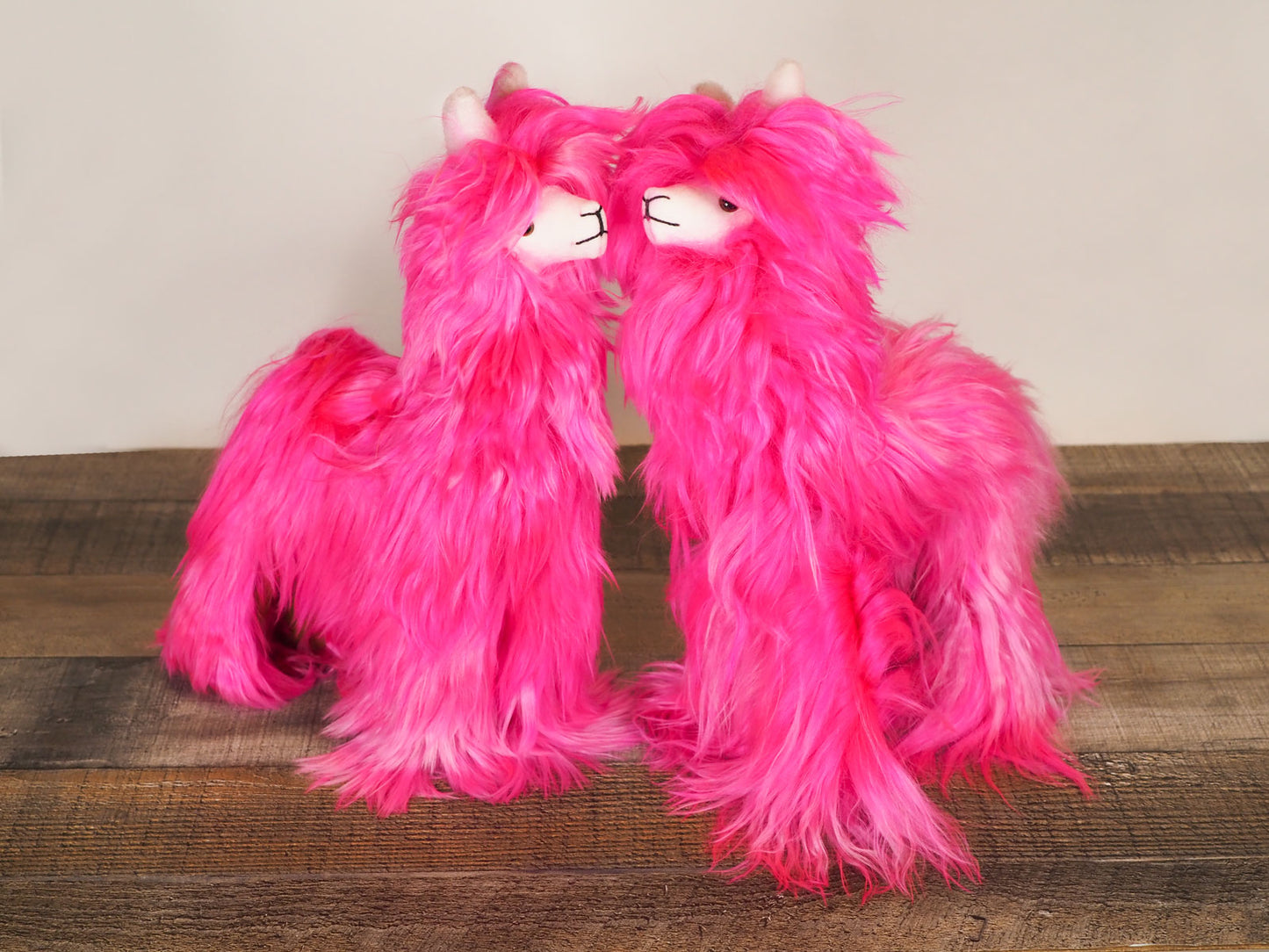 2 Hot Pink Alpaca Stuffed Animals together