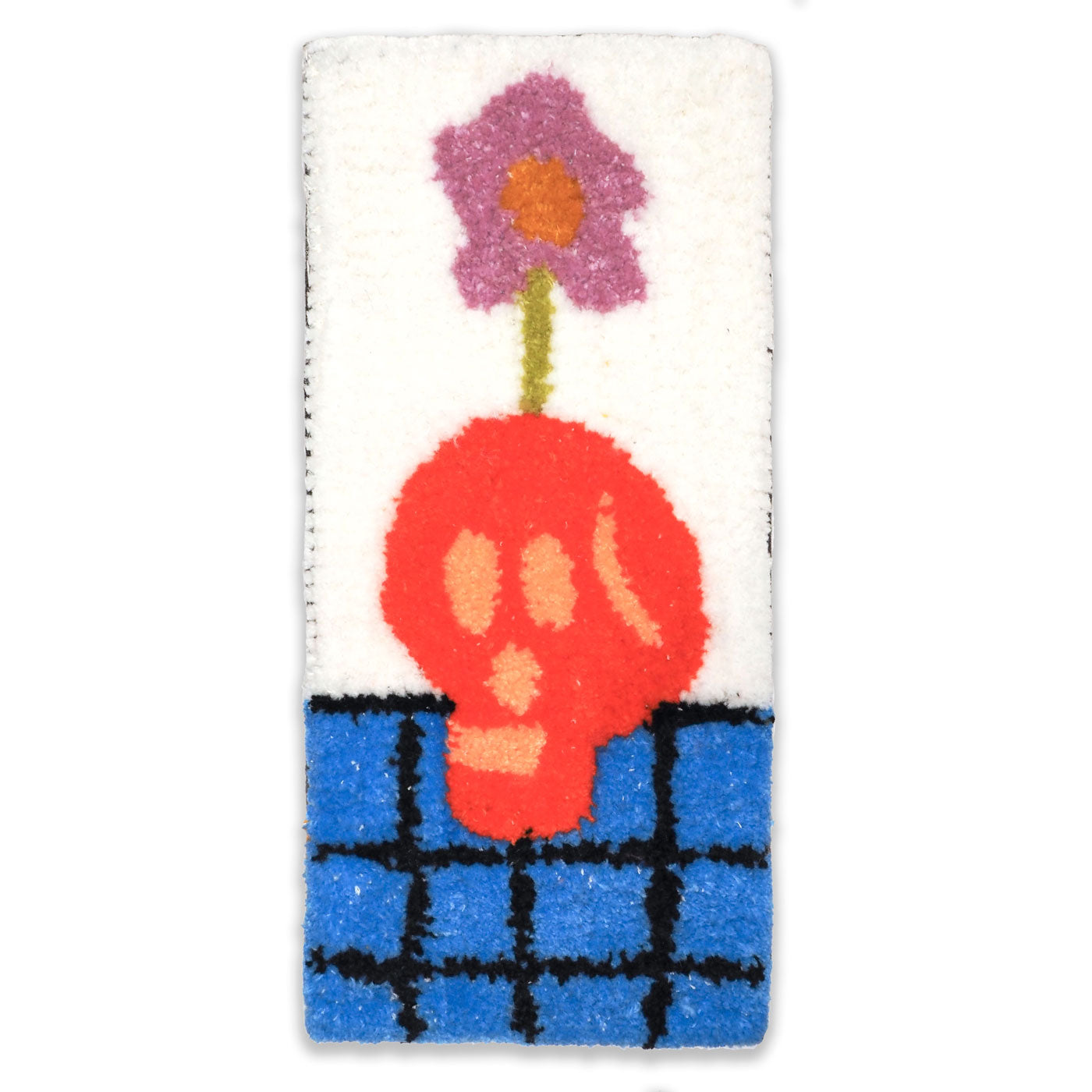 Hand-tufted wall hanging featuring a red skull on a blue checked surface with a purple flower coming out of the top of its head
