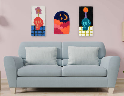 3 hand-tufted wall hangings above a blue couch