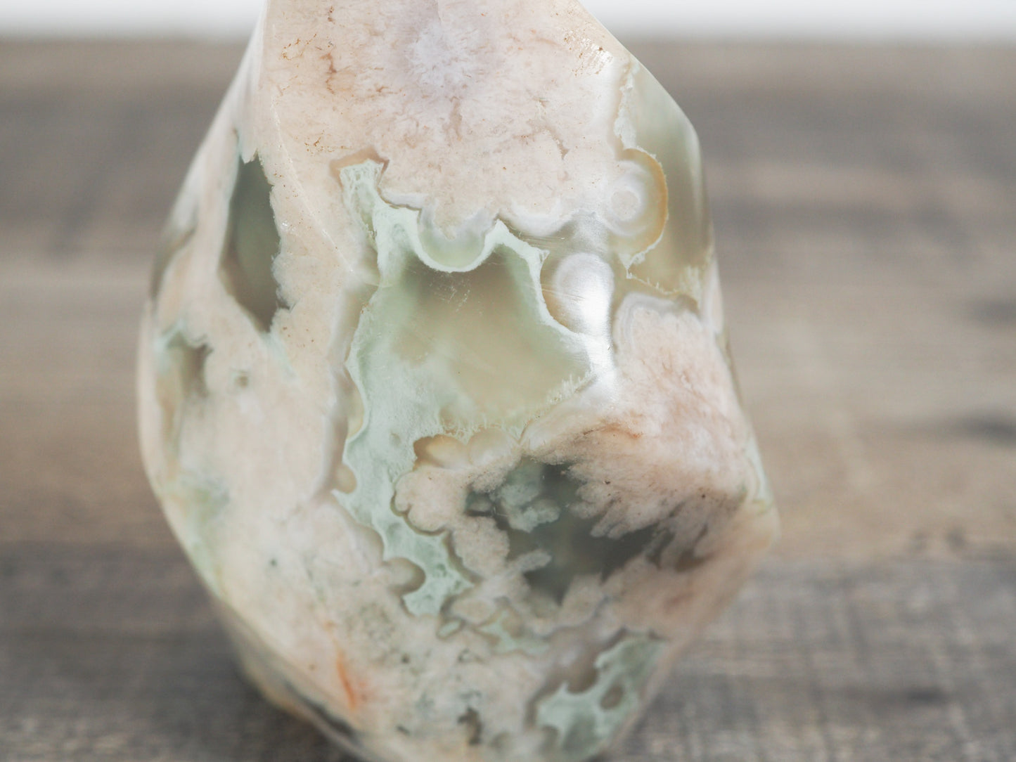 This sculpted flower agate flame with green inclusions is about 3" tall and 2" wide at its base. - Closeup