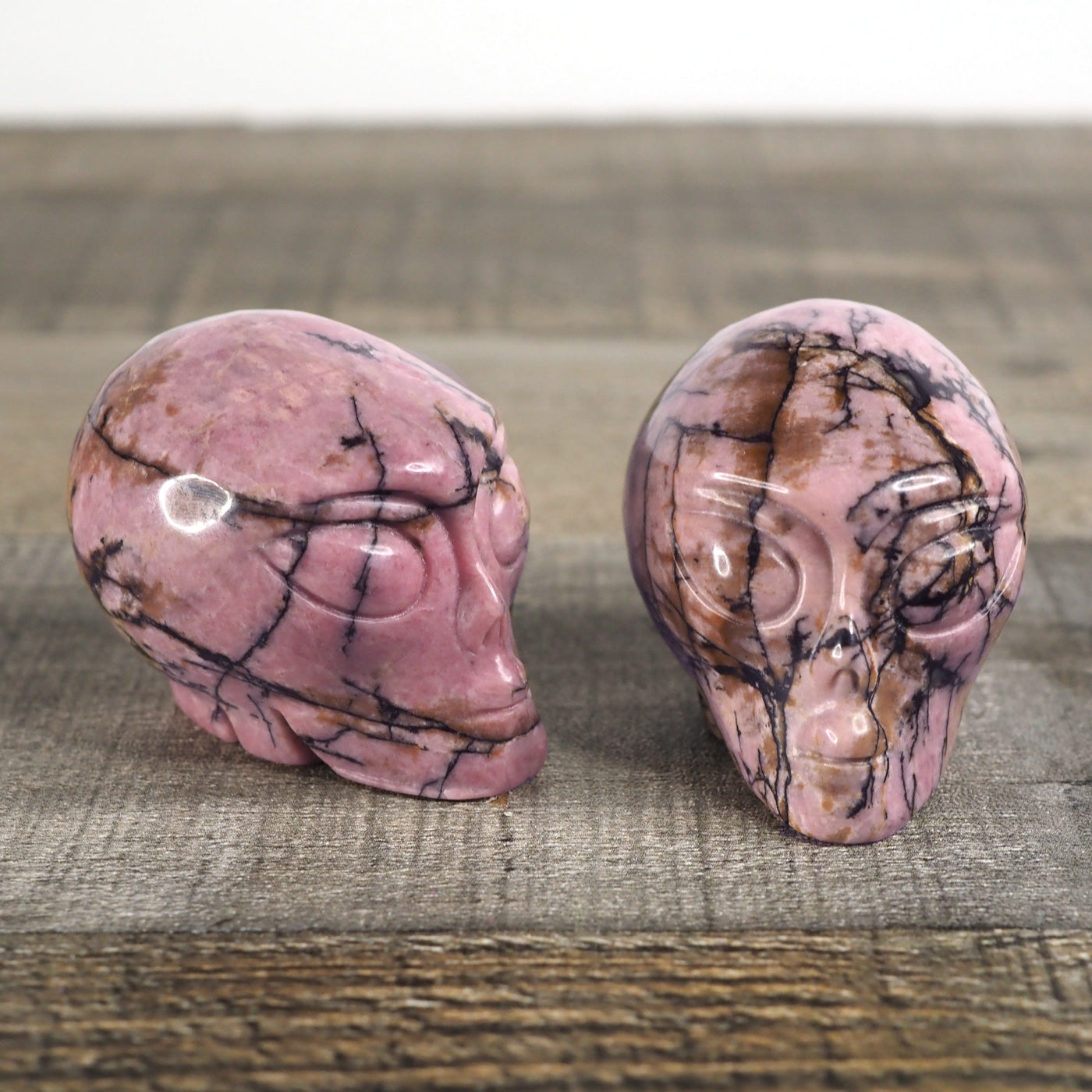 2 Hand-carved Rhodonite Alien Heads measuring about 2.25"