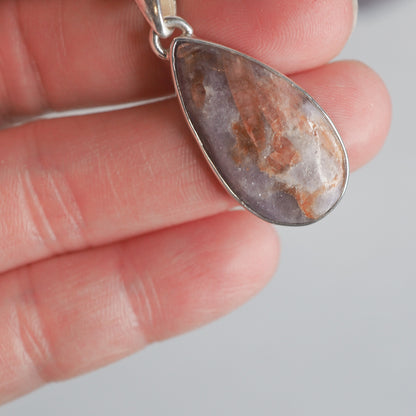 Pear-shaped Unicorn Stone Pendant held in a hand